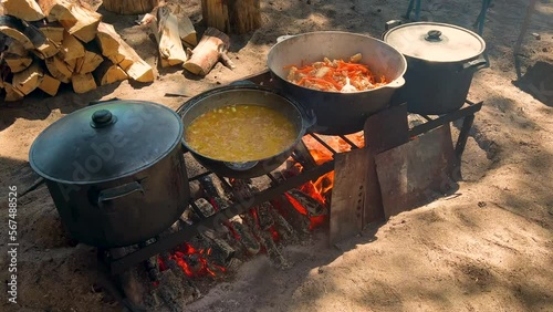 Cooking on a fire in the forest. Tourist preparing soup, porridge or pilaf on a hike. Camp on travel, place for bonfire, survival in summer