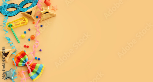 Purim celebration concept (jewish carnival holiday) over yellow background. Top view, flat lay