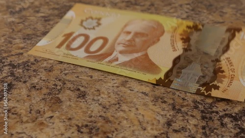 Falling Canadian 100 dollar polymer banknotes with a portrait of Robert Borden. Slow motion. photo