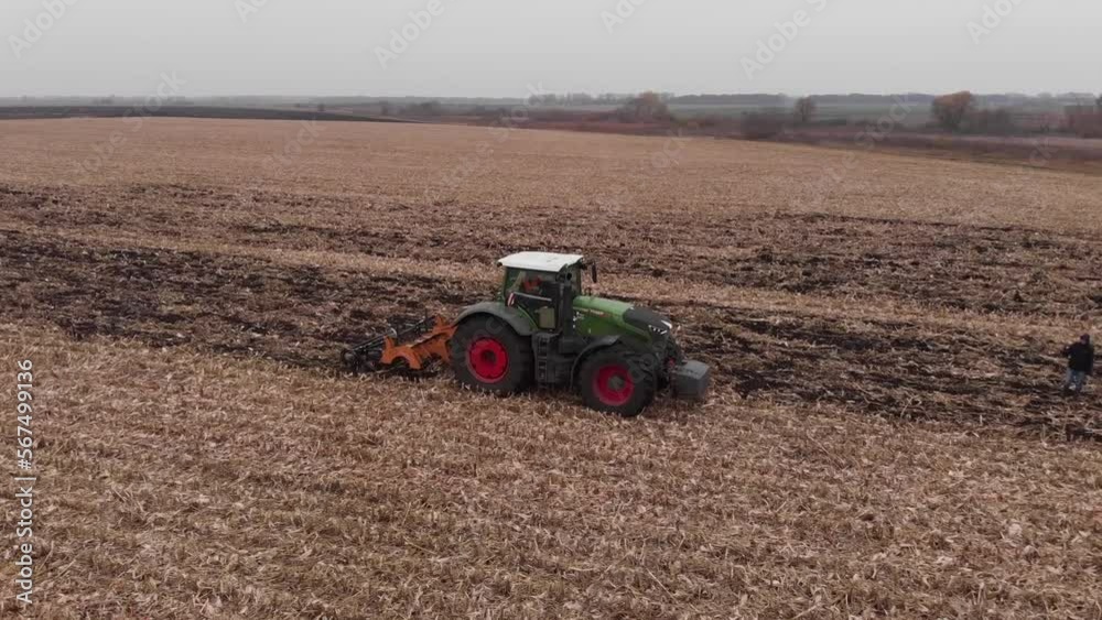 Tractor working in the field. Autumn tillage. Deep ripping with powerful tractor Tractor working in the field. Autumn tillage. Deep ripping with powerful tractor