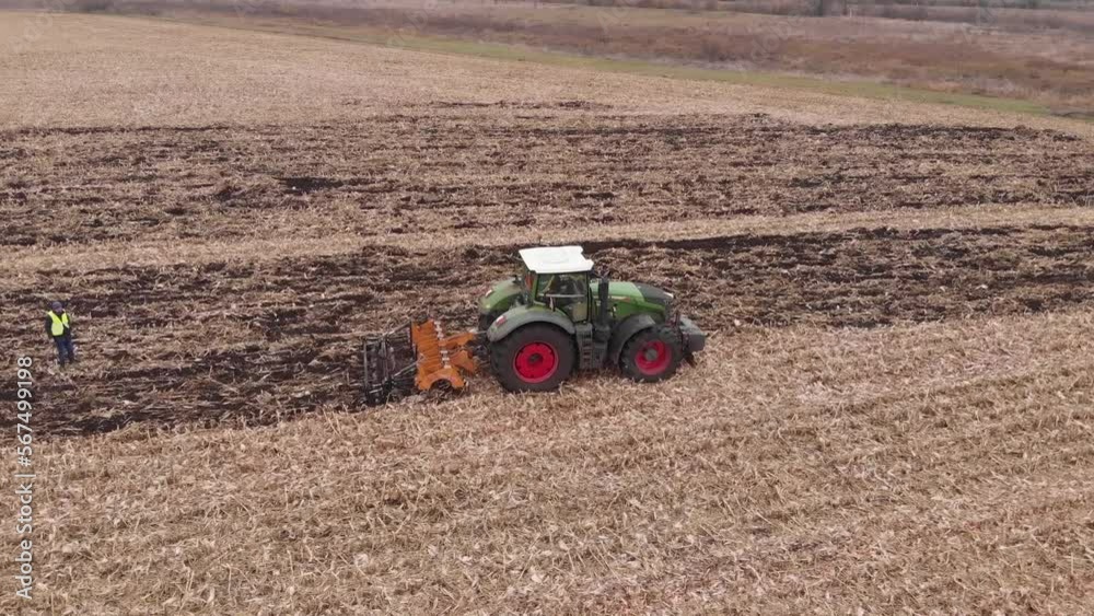 Tractor working in the field. Autumn tillage. Deep ripping with powerful tractor Tractor working in the field. Autumn tillage. Deep ripping with powerful tractor