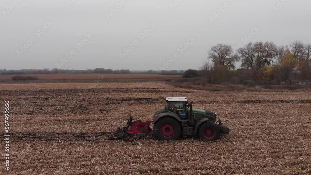 Tractor working in the field. Autumn tillage. Deep ripping with powerful tractor Tractor working in the field. Autumn tillage. Deep ripping with powerful tractor