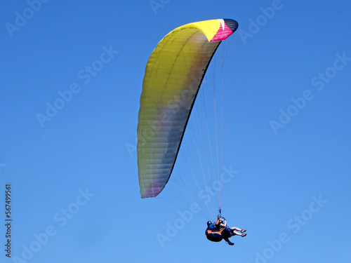 Tandem Paraglider flying in a blue sky 