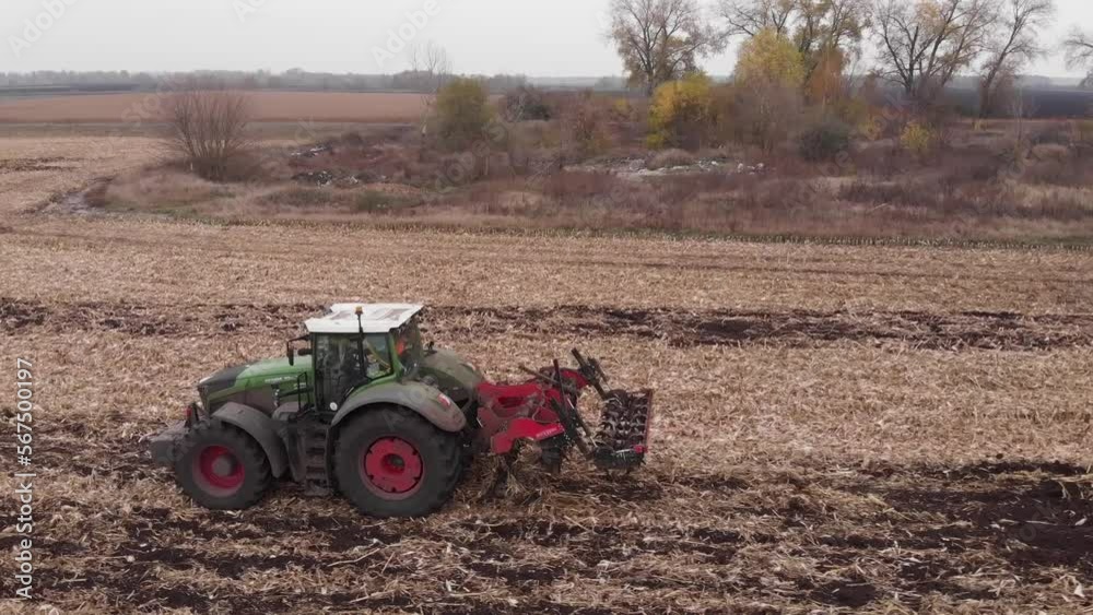 Tractor working in the field. Autumn tillage. Deep ripping with powerful tractor Tractor working in the field. Autumn tillage. Deep ripping with powerful tractor