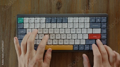 Hacker hands nervously hit buttons on keyboard lying on the wooden table. Expert at programming and solving problems using computer system to access information or find correct hotkey combination.