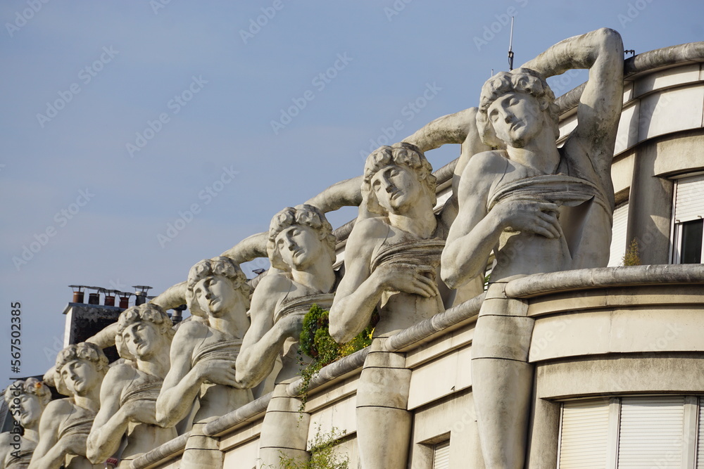 Obraz premium several statues of the same man decorating the top of a building in downtown Paris, France