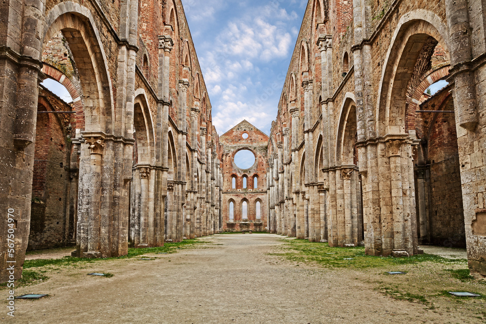 Fototapeta premium San Galgano abbey in Chiusdino, Siena, Tuscany, Italy. Roofless nave with colonnade of the medieval Gothic style church. It has been a location for films by Tarkovsky, Vadim and others