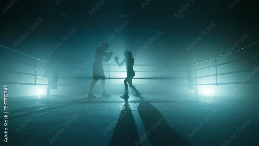 Close-up view of intensive training for gaining body strength. Unrecognized man and woman training in darkness. High quality 4k footage in cold teal blue foggy back light Close-up view of intensive training for gaining body strength. Unrecognized man and woman training in darkness. High quality 4k footage in cold teal blue foggy back light