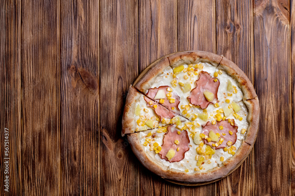 Delicious pizza with ham, pineapple, corn on a creamy base on woden background. Hawaiian pizza Delicious pizza with ham, pineapple, corn on a creamy base on woden background. Hawaiian pizza