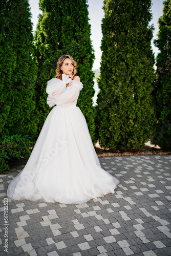 beautiful bride posing in a white delicate dress in the park.