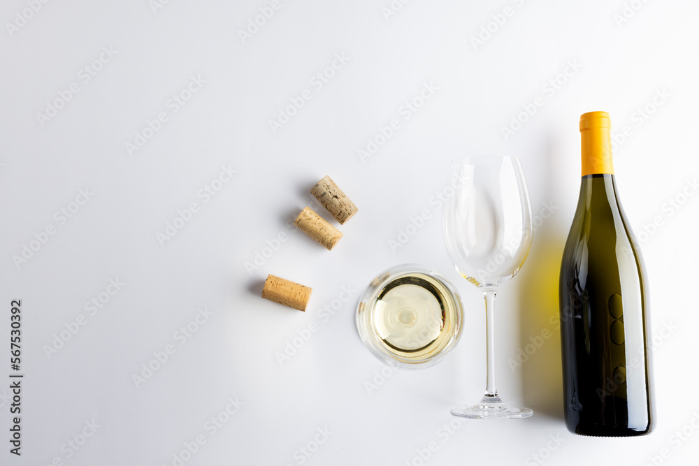 Bottle of white wine, glasses and corks on white background, with copy space Bottle of white wine, glasses and corks on white background, with copy space