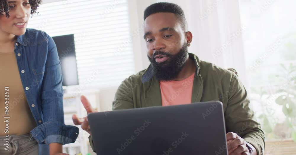 Diverse male and female friends using laptop and talking, working at home in slow motion Diverse male and female friends using laptop and talking, working at home in slow motion