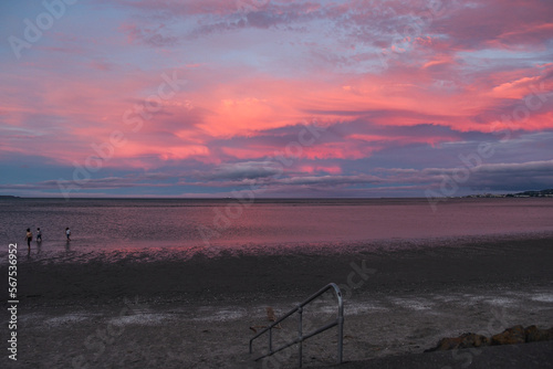 People on the bay  apocalyptic colourful sunset  pink clouds  Sandymount  Dublin  Ireland