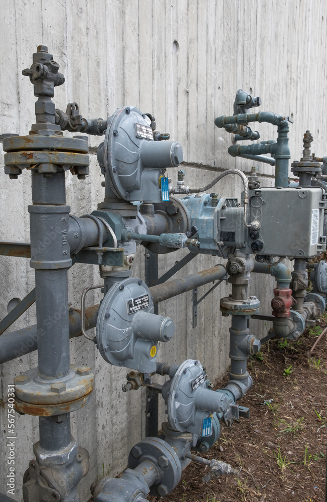 A vertical image of natural gas piping outside an apartment building downtown. A vertical image of natural gas piping outside an apartment building downtown.