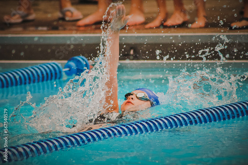 Girl swimming backstroke in pool photo