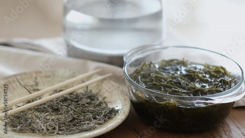 Dry and soaked seaweed on a wooden table. Preparing of laminaria salad photo