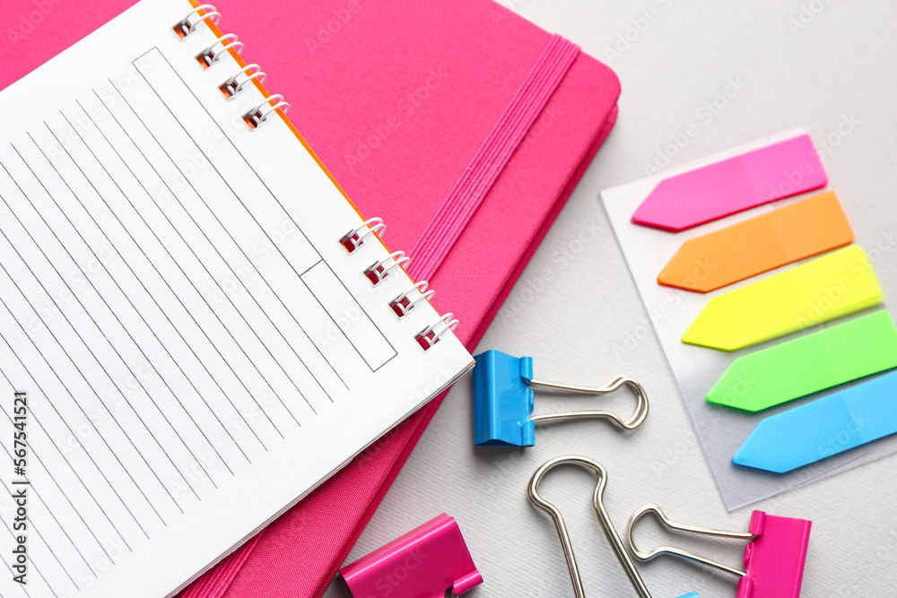 Notebooks, sticky notes and paper clips on light background, closeup Notebooks, sticky notes and paper clips on light background, closeup