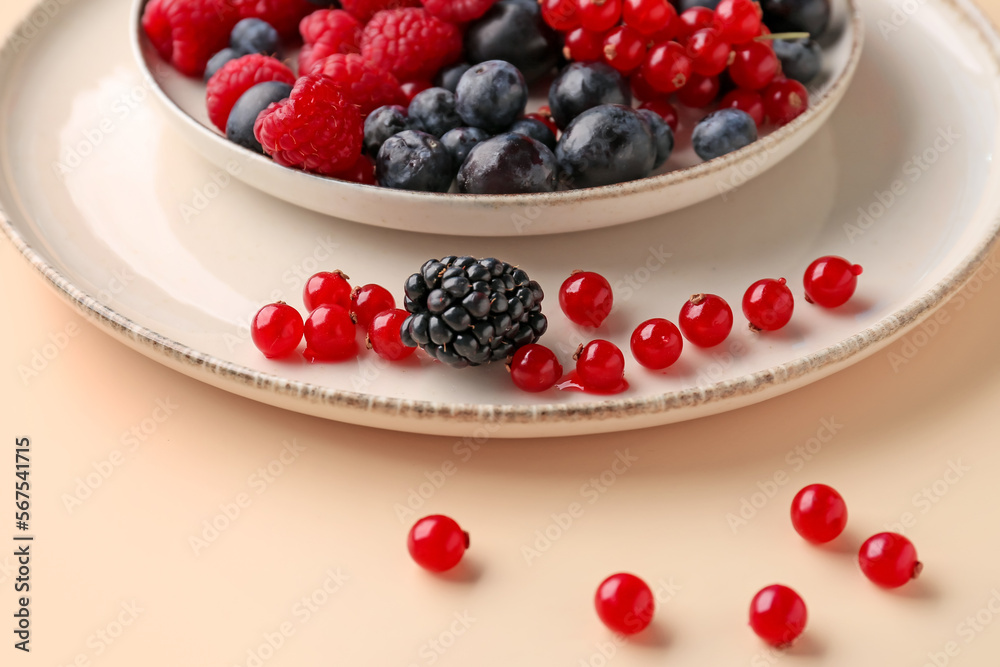 Plate with fresh berries on color background, closeup Plate with fresh berries on color background, closeup