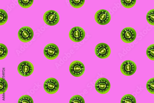 Colorful fruit pattern of fresh kiwi slices on vivid pink background. From top view