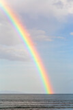 A rainbow on blue sky over endless water