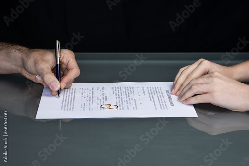 Couple goes through divorce signing papers. High quality photo