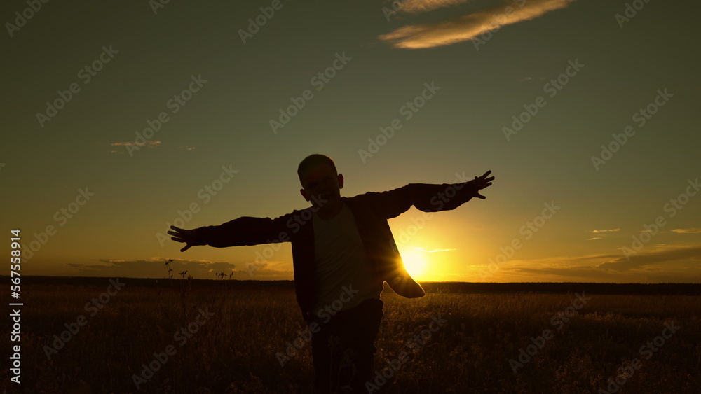 Boy wants to become pilot astronaut. Slow motion. Silhouette, Teenager dreams of flying, becoming pilot Airplane. Happy teen boy plays with toy plane on field, sunset. Children play with toy airplane