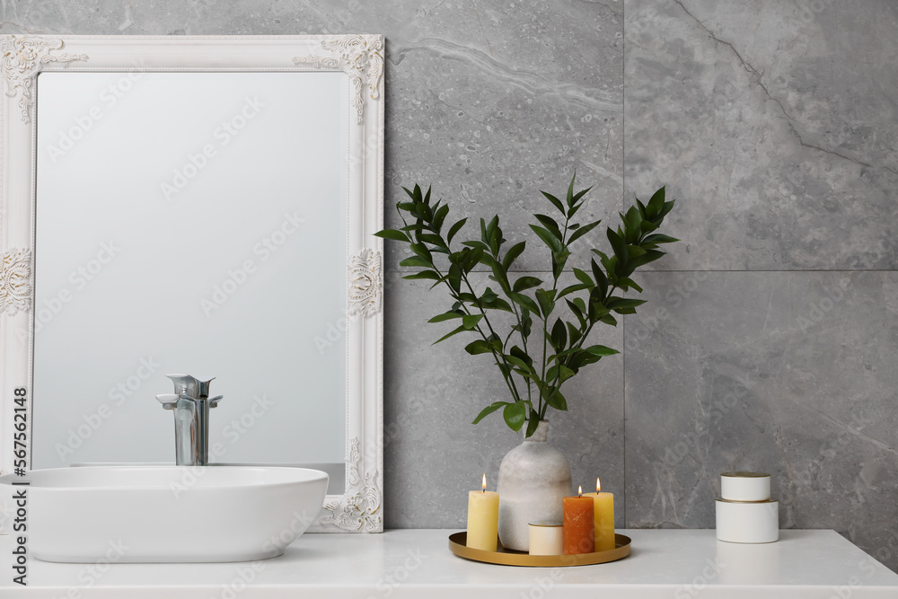Beautiful plant in vase and burning candles near vessel sink and mirror on  bathroom vanity foto de Stock | Adobe Stock