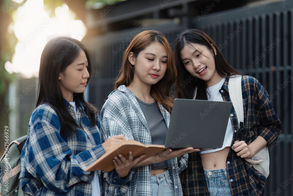 Beautiful young Asian woman college student with friends at outdoors. College student working on the college campus Beautiful young Asian woman college student with friends at outdoors. College student working on the college campus