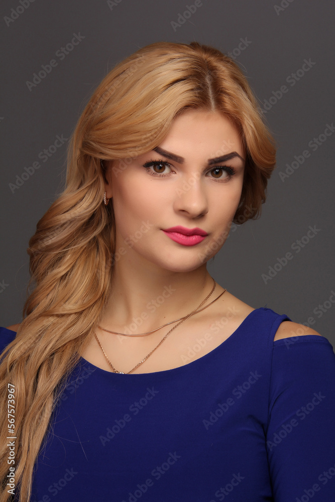 portrait of a blonde girl with blonde hair in a blue dress in a studio room, with makeup and hairstyle, red lips and manicure portrait of a blonde girl with blonde hair in a blue dress in a studio room, with makeup and hairstyle, red lips and manicure