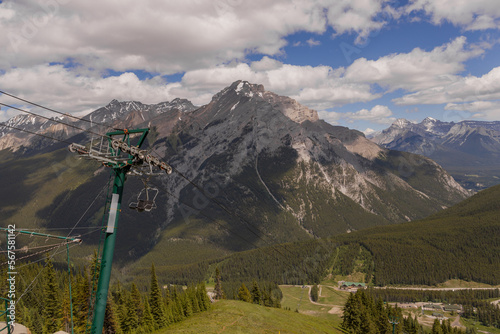 Mountain landscape - coniferous forest, beautiful blue sky with clouds. Summer tourism - ski lift to the mountain. Banff, Alberta, Canada. Rocky Mountains