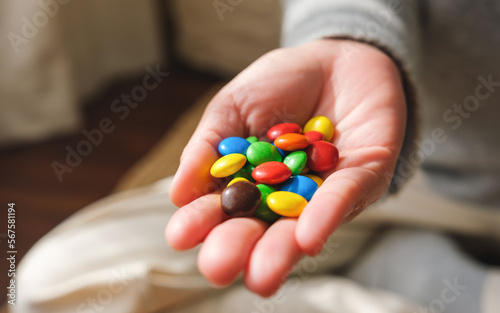 Closeup image of a hand holding colorful chocolate candy