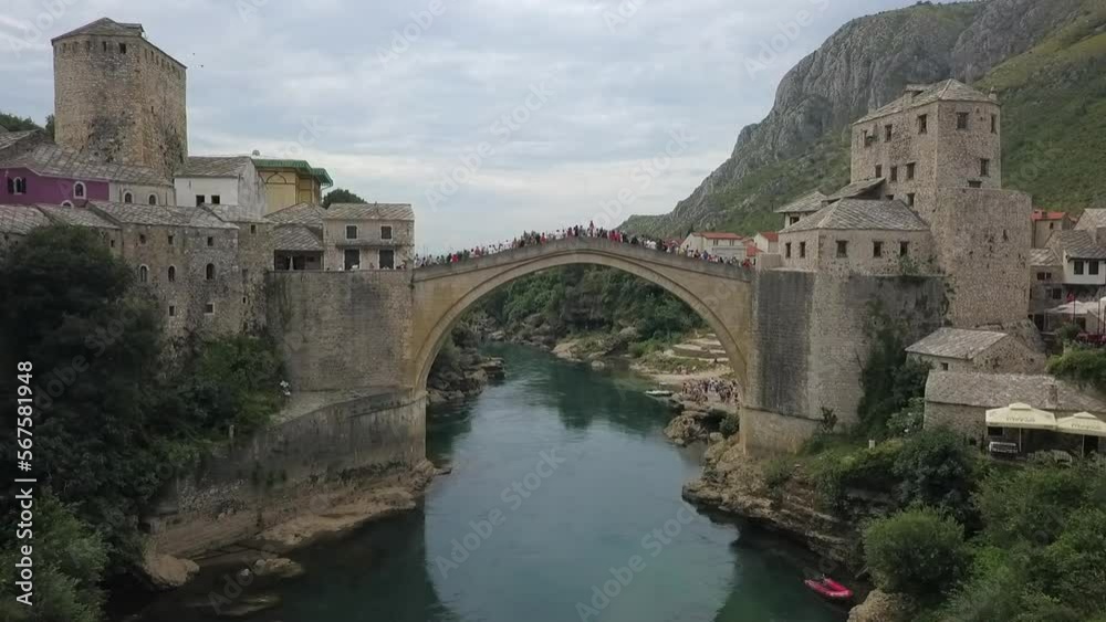Tourists, locals gather on Mostar old bridge high over Neretva River Tourists, locals gather on Mostar old bridge high over Neretva River