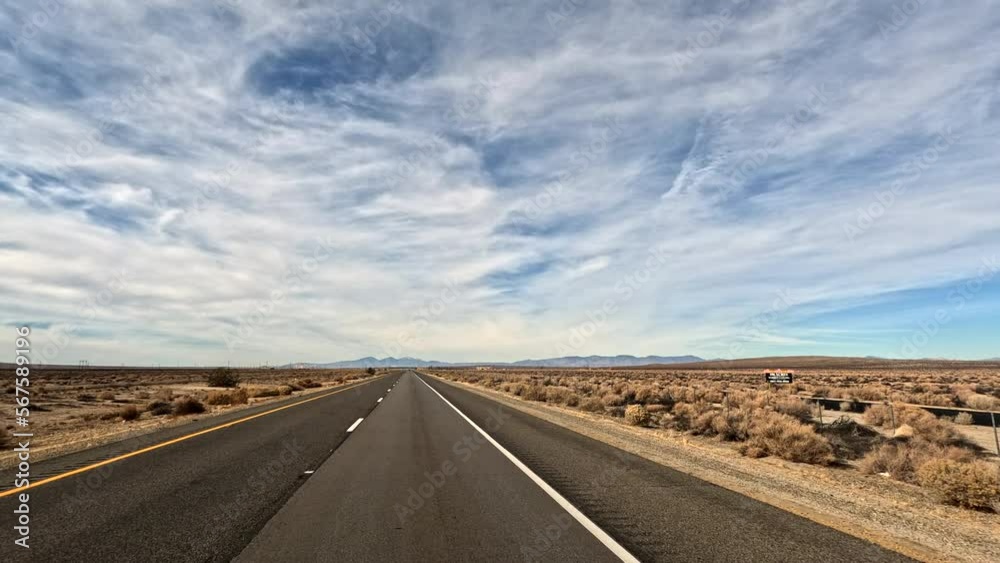 Driving through the Mojave Desert with wispy clouds in the sky Driving through the Mojave Desert with wispy clouds in the sky