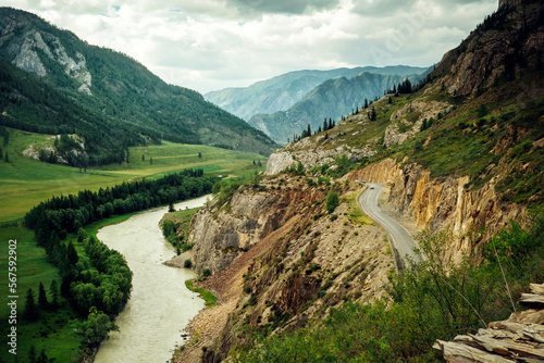 Curve road in the mountains. Chuisky tract with moving cars, Altai Republic, Siberia. A picturesque section of the federal highway along the Katun River. photo