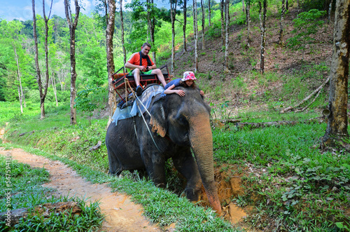 Pretty young girl and her dad doing an elephant trek in Khao Sok National Park in Thailand photo