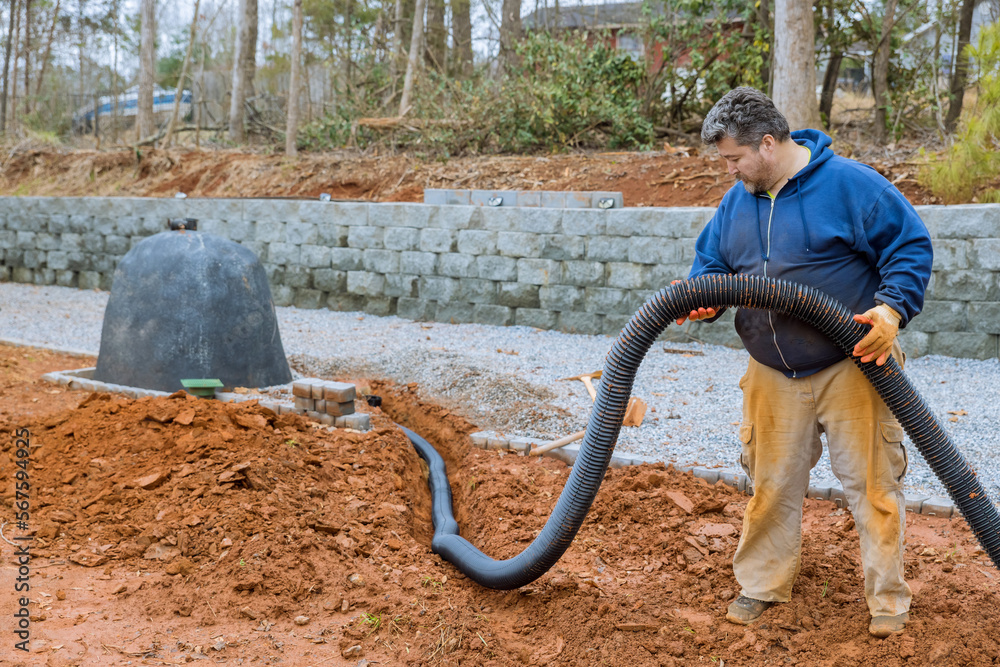 Putting down drainage pipes for rainwater on parking lot which is
