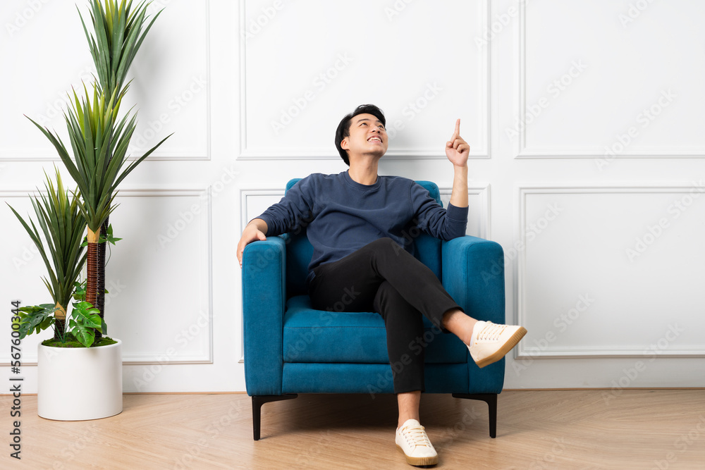 portrait of asian man sitting on sofa at home
portrait of asian man sitting on sofa at home