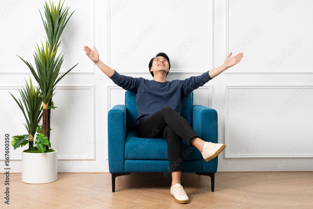 portrait of asian man sitting on sofa at home
