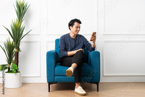 portrait of asian man sitting on sofa at home
