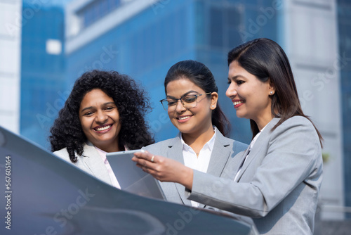 Photography Businesswoman team working online outdoors using a tablet computer and smiling