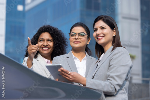 Photography Businesswoman team working online outdoors using a tablet computer and smiling