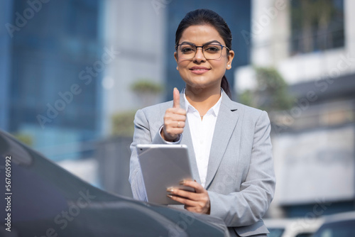 Photography Young business woman pointing okay, behind her colleagues discussing
