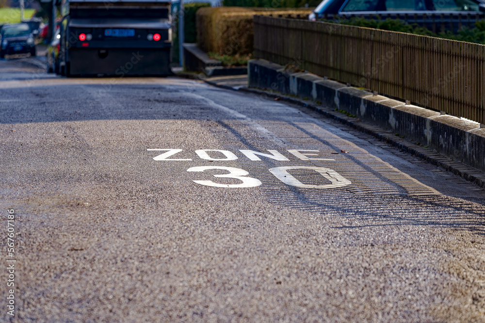 Obraz premium Close-up of road marking speed limit zone 30 kilometers per hour at urban road at City of Zürich district Seebach on a sunny winter day. Photo taken January 31st, 2023, Zurich, Switzerland.