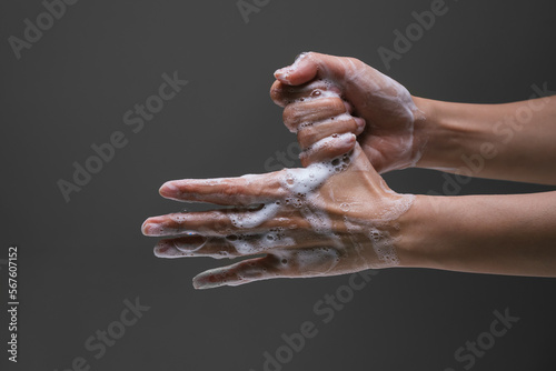 Lady washing hand rubbing with soap to prevent the spread of bacteria and virus. Personal hygiene concept. Hand wash instruction. Isolated black background. Corona virus prevention.