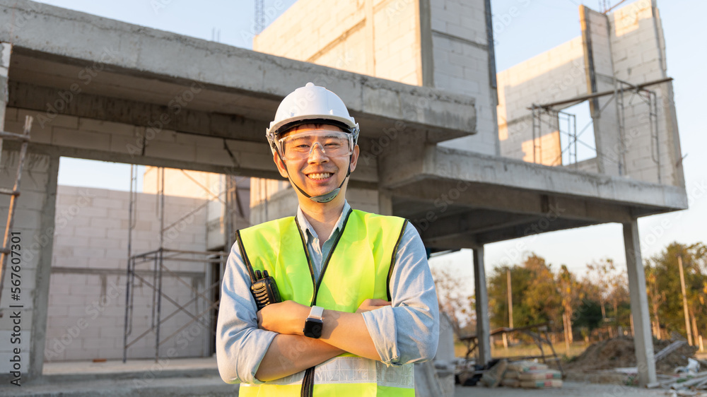 Skilled engineer inspects factory construction and uses a radio to chat with colleagues working on the field, Engineer working outdoors with blueprints and wearing protective safety gear. Skilled engineer inspects factory construction and uses a radio to chat with colleagues working on the field, Engineer working outdoors with blueprints and wearing protective safety gear.