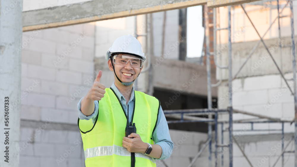 Professional engineer inspecting the construction of a house or factory building and giving a thumbs up showing readiness and good performance, Engineer's safety suit and helmet. Professional engineer inspecting the construction of a house or factory building and giving a thumbs up showing readiness and good performance, Engineer's safety suit and helmet.