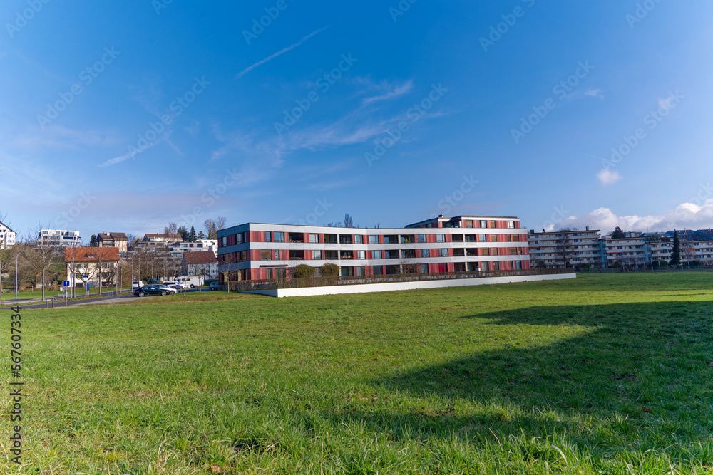 Scenic view of beautiful modern red and gray senior residence at City of Zürich district Seebach on a sunny winter day. Photo taken January 31st, 2023, Zurich, Switzerland.