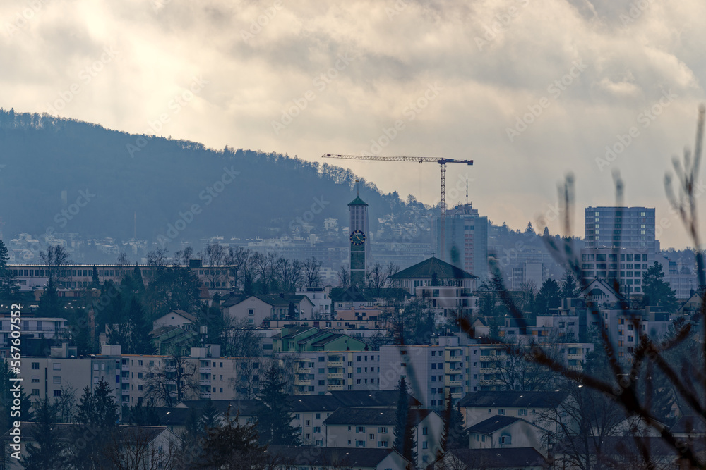 Skyline of City of Zürich on a cloudy winter noon seen from hill at district Seebach. Photo taken January 31st, 2023, Zurich, Switzerland.