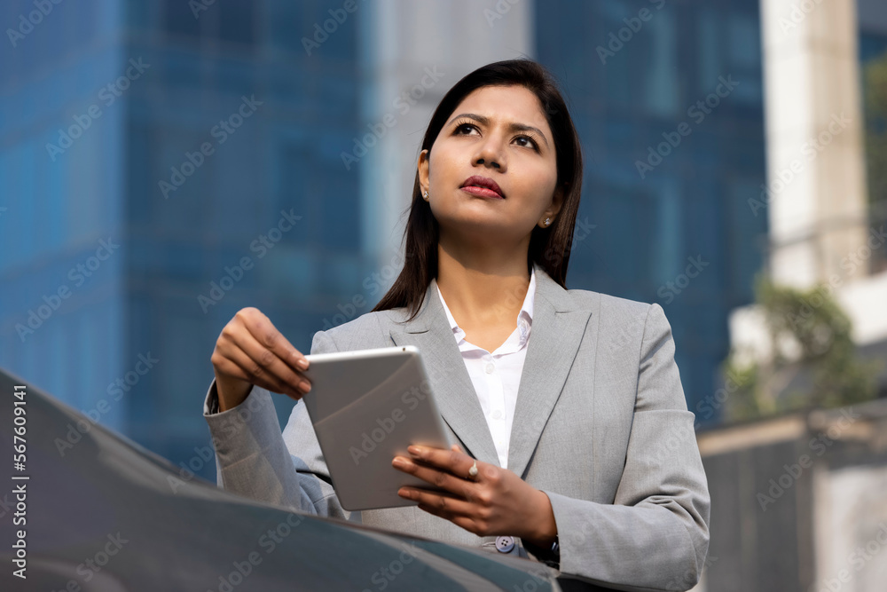 Happy businesswoman holding digital tablet outside office building Happy businesswoman holding digital tablet outside office building