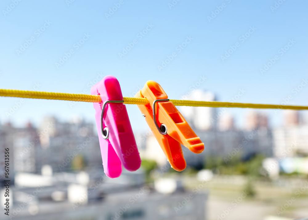 Colorful clothespins against the blurred background. Plastic clothespins in different colors. Blurred image, selective focus
